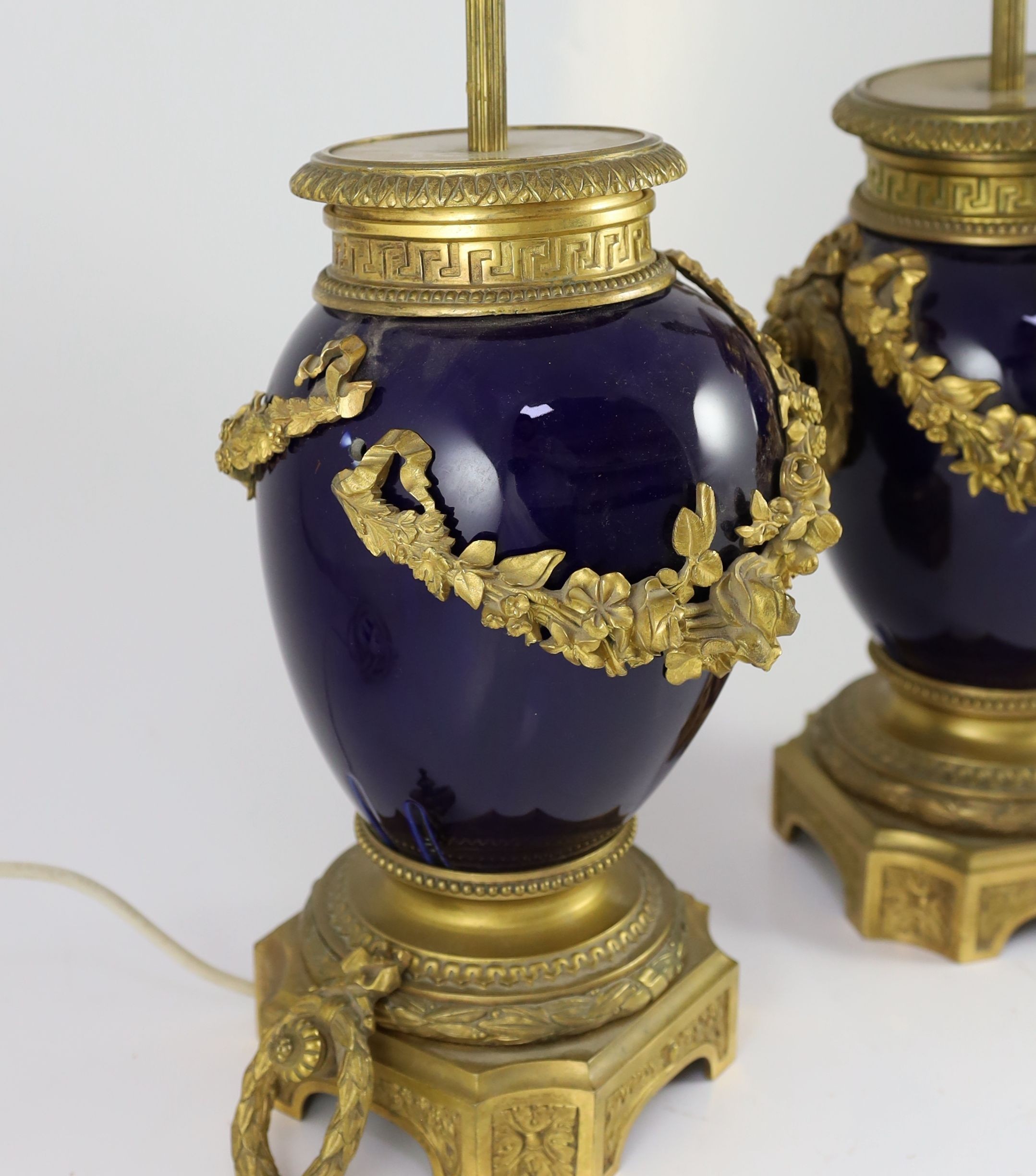 A pair of Louis XVI style ormolu mounted bleu du roi porcelain table lamps, width 23cm height 40cm